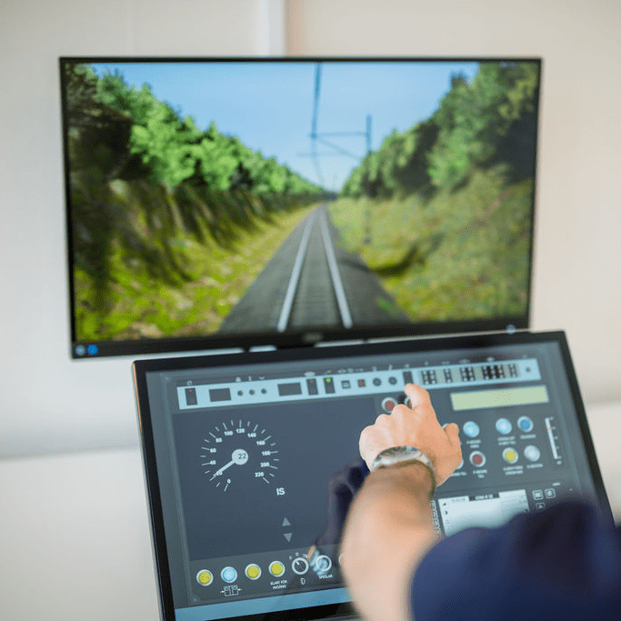 CGI front view and touchscreen virtual instrumentation of the Nano Simulator, showing a realistic 3D railway track environment.